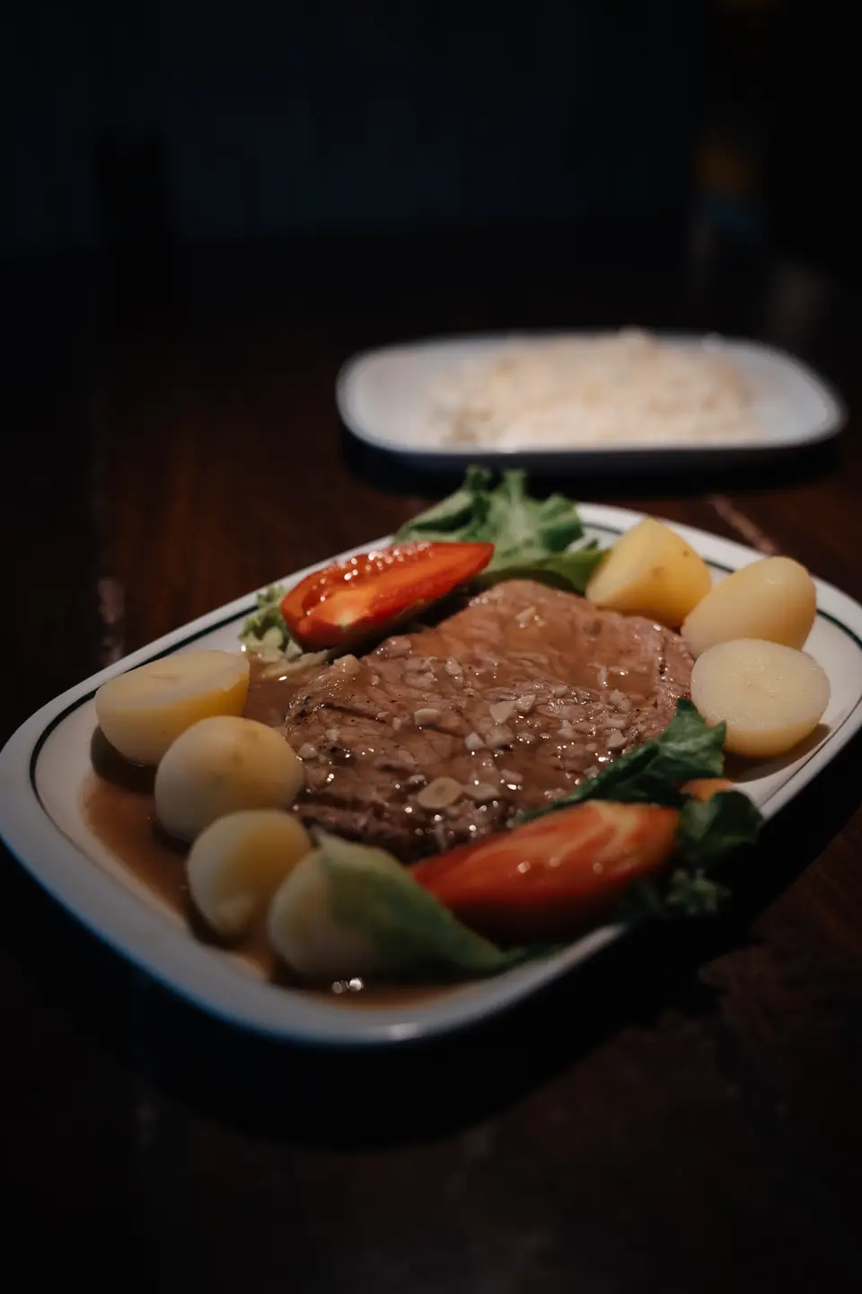 Um bife com batata, tomate e salada