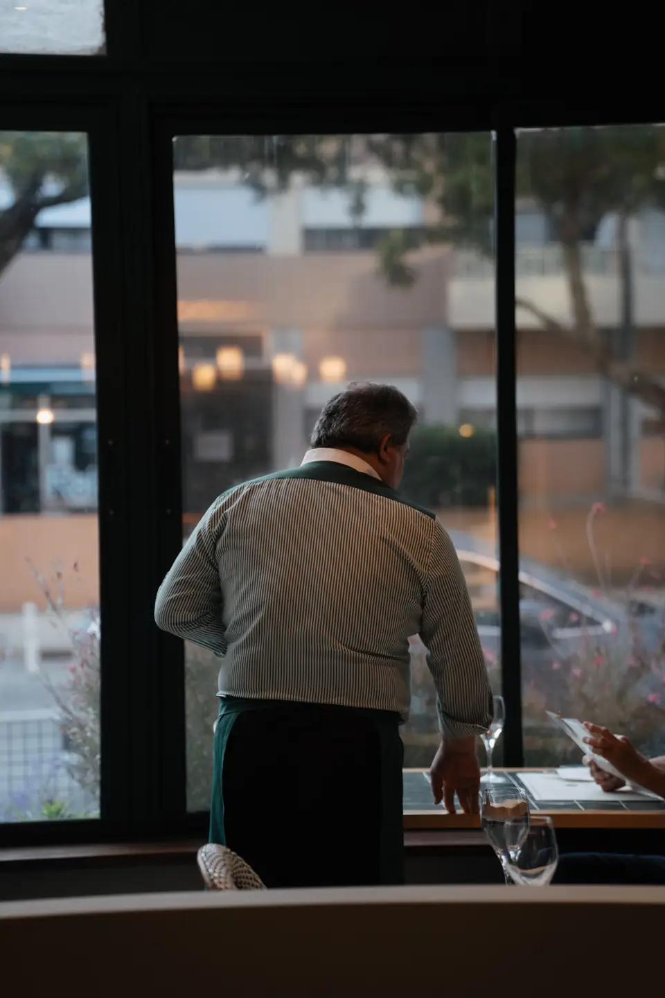 Um empregado junto à janela, a atender uma mesa