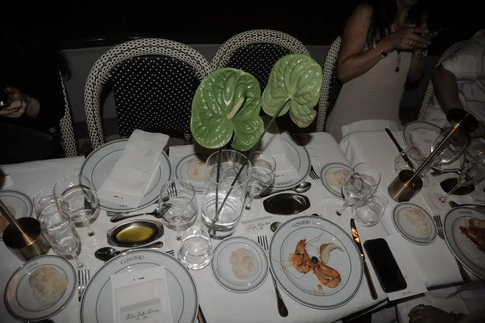 Mesa posta com os pratos e copos do Convívio